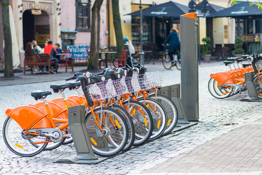 Sustainable transport. Row of bikes parked for hire in the old town, city bikes rent parking, public bicycle sharing system, bike sharing program