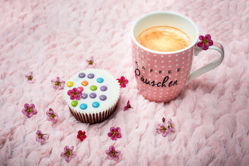 Rosa Kaffeetasse mit Muffin und Smarties 