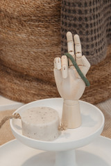 Natural handmade round soap piece on a rope and human hand in patient gesture