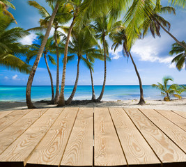 Fototapeta na wymiar Empty wooden tabletop for Your product advertisement. Tropical beach in Caribbean sea at Saona island in the background, Dominican Republic