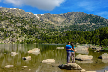 Fototapeta na wymiar Hikers enjoying the views at the Malniu Lake (Cerdanya province, Catalonia, Spain)