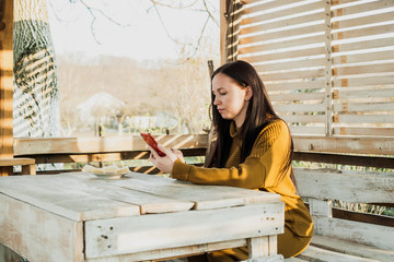 woman working on the mobile phone. wooden arbor