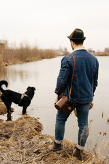 man walks a dog by the lake
