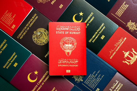 Kuwait diplomatic passport on the background of various documents of the world.