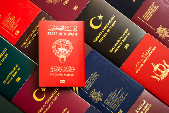 Kuwait diplomatic passport on the background of various documents of the world.