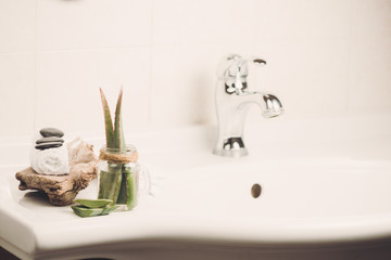 A bathroom sink inside house with aloe soap and stones