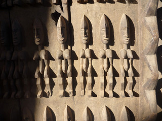 stara tradycyjna afrykańska płaskorzeźba na drewnianych drzwiach budynku w timbuktu przedstawiająca ludzkie postaci