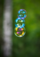 three soap bubbles on a green background