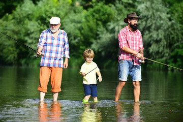 Outdoors active lifestyle. Men day. Male multi generation family. Grandpa and grandson are fly fishing on river.