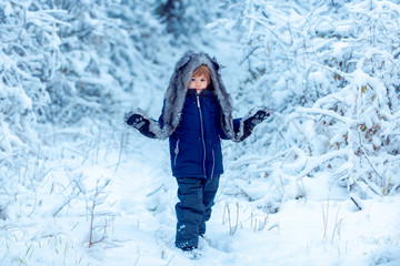 Fototapeta na wymiar Happy children on nature walks in the winter. Well dressed enjoying the winter. Winter portrait of happy cute child.