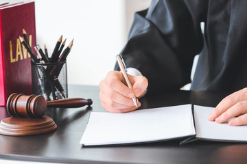 Male judge with documents at table in office, closeup