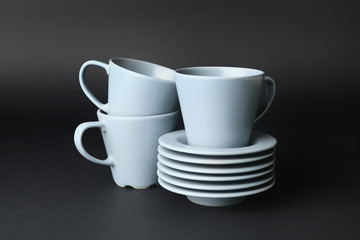 Blank cups and saucers on dark background