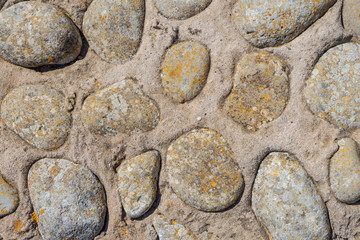 floor made up of tiles with small stones embedded in them, of different colors and sizes