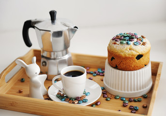 Easter still life. Coffee and cake. Espresso maker moka pot. White dishes, ceramic easter bunny. Colored coffee beans