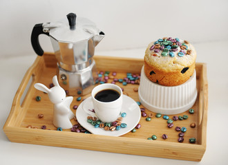 Easter still life. Coffee and cake. Espresso maker moka pot. White dishes, ceramic easter bunny. Colored coffee beans