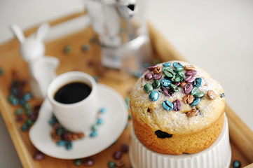Easter cake sprinkled colored pearl coffee beans close up. Espresso maker moka pot and cup of coffee on the background