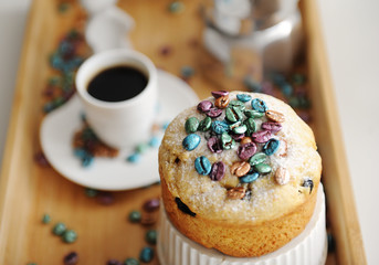 Easter cake sprinkled colored pearl coffee beans close up. Espresso maker moka pot and cup of coffee on the background
