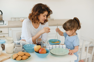 A young mother spends time with her little daughter at home.