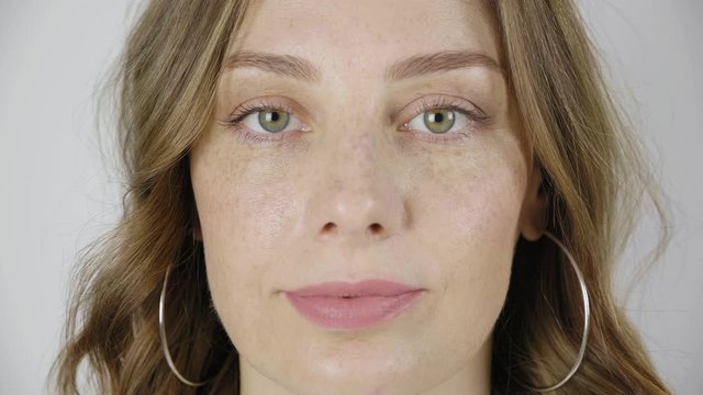 Close up of woman s face, female opening her beautiful green eyes, Attractive Ginger. Natural Beauty with Freckles. Gorgeous woman with long Eyelashes and Attractive Appearance. Slow motion. 4k