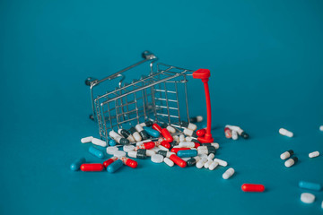 a fallen basket in a pile of pills on a blue background