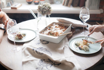 Date of a young couple. Man and woman. Vegetable casserole of cauliflower and zucchini. Laid dinner table. Plates with cutlery. Dietary food.
