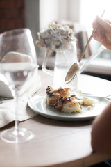 Vegetable casserole of cauliflower and zucchini. Laid dinner table. Plates with cutlery. Dietary food.