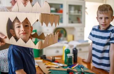 	
Smiling boy wearing a cardboard dinosaur costume