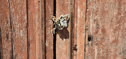 Abandoned house with old and ruined door closed with double padlock and chains
