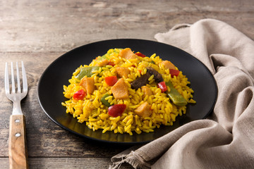 Fried rice with chicken and vegetables on wooden table