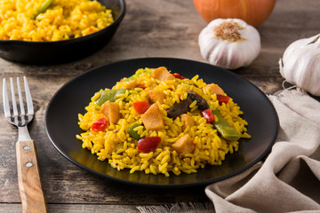 Fried rice with chicken and vegetables on wooden table