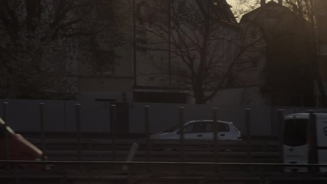 moving shot of silver car bypassing traffic at rush hour with  sunrise backlight