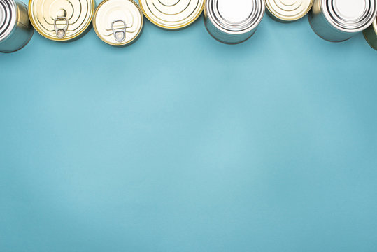 top view of cans on blue background with copy space, food donation concept