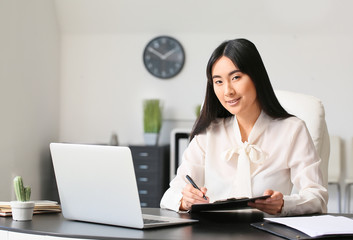 Beautiful Asian secretary working in office