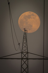 Setting Super Moon - power lines and towers in ftont of the super moon