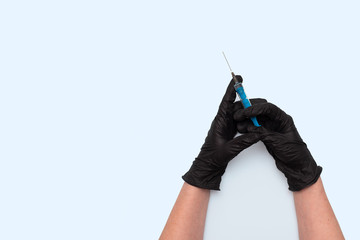 Hands in black protective gloves with a syringe. Medicine,