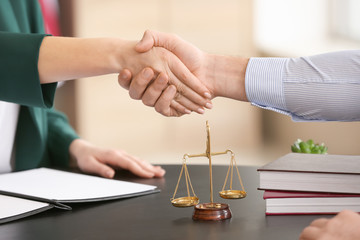 Female judge and client shaking hands in office, closeup