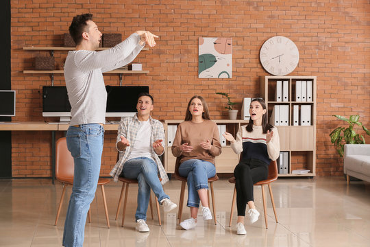 Team of business people playing charades in office