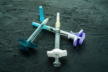  cosmetology  injections. Plastic syringe on black background. Medical syringe. botox filler...