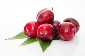 plums with plum leaves on a white background