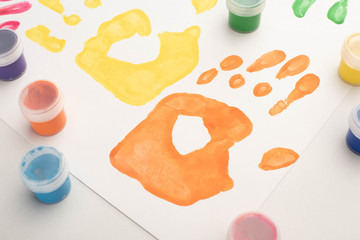 close up of colorful handprints and paints on white for World Autism Awareness Day
