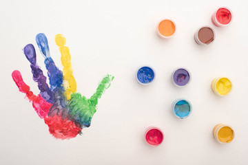 top view of colorful handprint and paints on white for World Autism Awareness Day