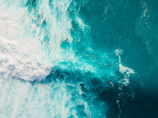 Wave with foam in blue ocean. Aerial view of barrel waves. Top view