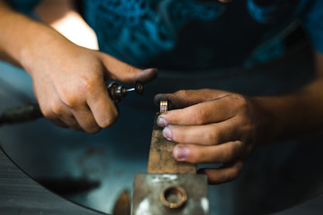 Master of jewelry while working on making a gold ring. Top view. 