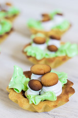 Cupcakes set. Cake basket with mushrooms. cupcake with cartoon style decorative mushrooms and leaves made from cream. Cake mushrooms white cream on white plate. Homemade mushroom-shaped cookies