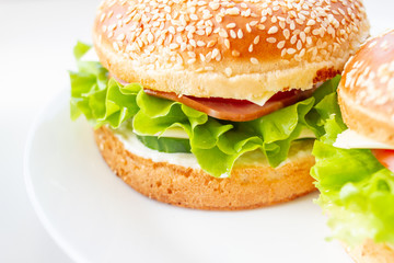 Sandwich with ham, cheese and lettuce in a sesame bun. Closeup of home made sandwich.
