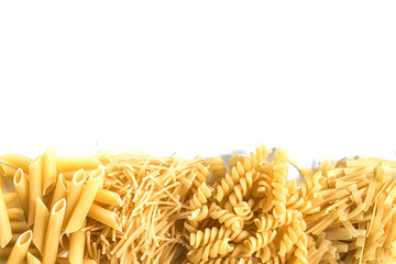 Different dry pasta and noodles on a white background. Free space for text.
