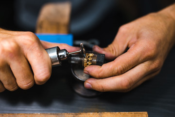 Master of jewelry while working on making a gold ring. Top view. 
