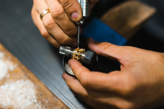 Master goldsmith while working on jewelry on the of work table.