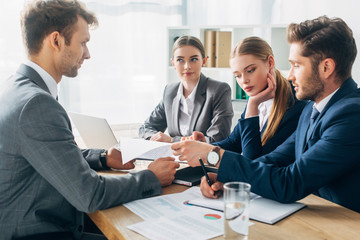 Selective focus of employee with resume during job interview with recruiters in office