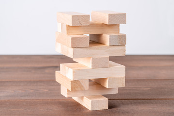 Tower from wooden blocks. Game jenga on wooden table. Architecture concept